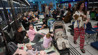 תופסים מחסה בשעת אזעקה במהלך ימי שאגת הארי בתחנת הרכבת הקלה רמת גן