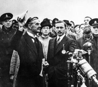 צ'מברלין מנופף בהסכם מינכן ב־1938. "איזה מפגרים", הפטיר מקבילו הצרפתי למריעים לו | צילום: אי-פי