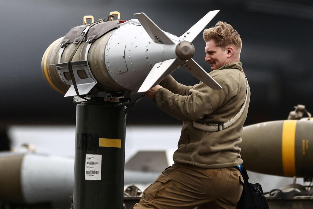A US Air Force crew member handles a munition at RAF Fairford in Britain for use by a B-1 Lancer bomber (Photo: AFP/Henry Nicholls) מפציץ B-1 Lancer של צבא ארה"ב בבסיס פיירפורד בבריטניה