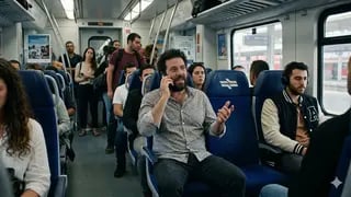 נוסע מדבר בטלפון ברכבת מלאה באנשים