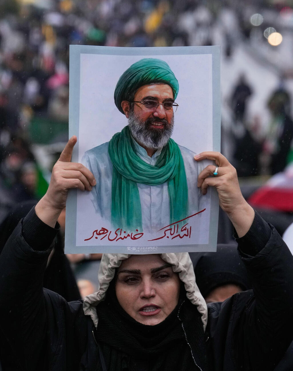 An informed source told The Media Line that, in reality, no individual leader exists, and that a five-member council, in coordination with the heads of the three branches of government, makes the principal decisions, while Khamenei’s office writes texts and statements attributed to him in place of an actual leader (Photo: AP Photo/Vahid Salemi) תומכי המשטר ב איראן מניפים תמונות של המנהיג העליון החדש מוג'תבא חמינאי