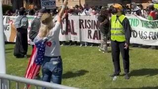 Aya Shechter with an American and Israeli flag at UCLA stands alone against anti-Israel demonstrators during a permitted pro-Israel rally