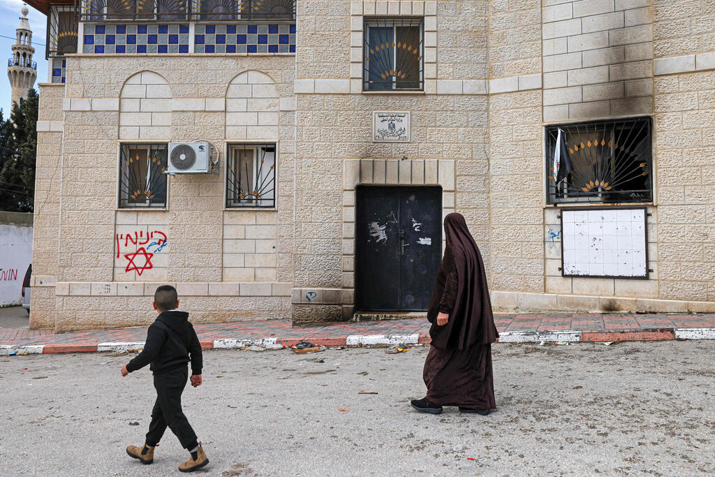 Palestinians inspect damage in the village of Jalud after a suspected settler attack involving arson, clinic vandalism and graffiti (Photo: Zain JAAFAR / AFP) הנזקים בכפר ג’אלוד