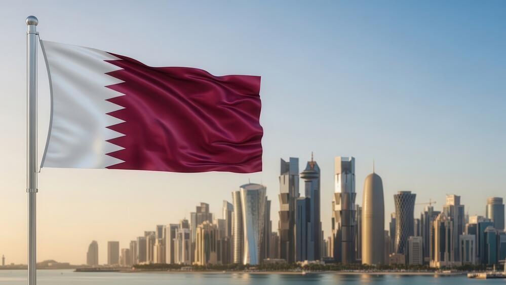 Qatar, Doha (Photo: Gfx Nadia/Shutterstock) דגל קטאר על רקע עיר הבירה דוחא