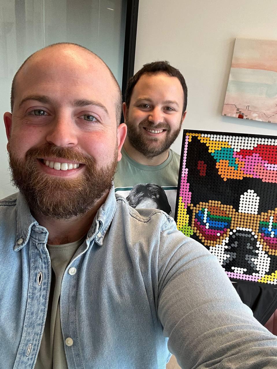 People and Collectors podcast host Bar Gindy and LEGO artist Elan pose with one of Elan’s colorful custom mosaic portraits (Photo: Bar Gindy) People and Collectors podcast host Bar Gindy and LEGO artist Ilan pose with one of Ilan’s colorful custom mosaic portraits