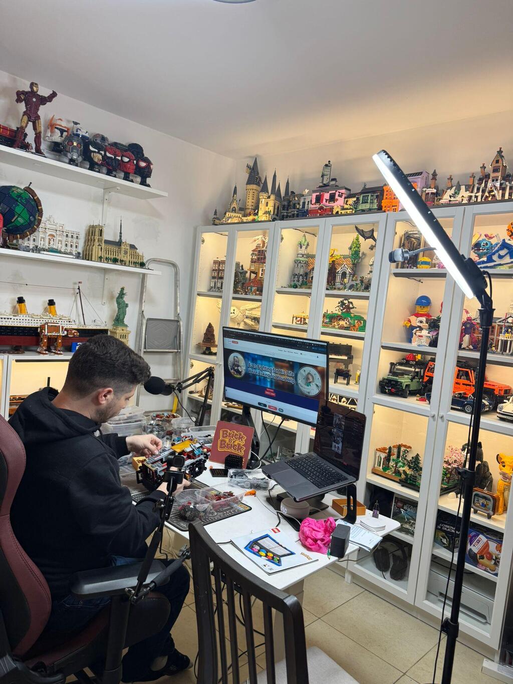 Elliott works on a LEGO build in his home studio, where he documents daily sessions online while caring for his son, AJ, during the toddler’s recovery (Photo: Courtesy) Elliott works on a LEGO build in his home studio, where he documents daily sessions online while caring for his son, AJ, during the toddler’s recovery