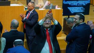 איתמר בן גביר במליאת הכנסת לאחר ההכרזה על אישור חוק עונש מוות למחבלים עם שמפניה בידו