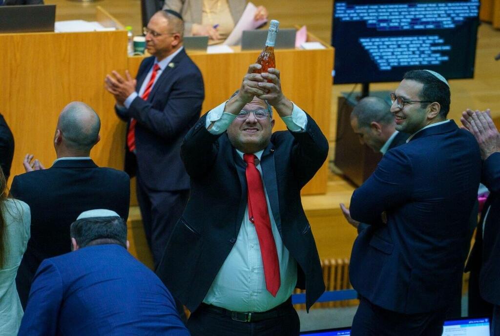 איתמר בן גביר במליאת הכנסת לאחר ההכרזה על אישור חוק עונש מוות למחבלים עם שמפניה בידו