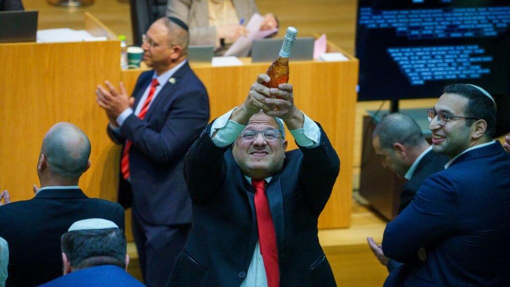 איתמר בן גביר במליאת הכנסת לאחר ההכרזה על אישור חוק עונש מוות למחבלים עם שמפניה בידו