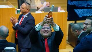 איתמר בן גביר במליאת הכנסת לאחר ההכרזה על אישור חוק עונש מוות למחבלים עם שמפניה בידו