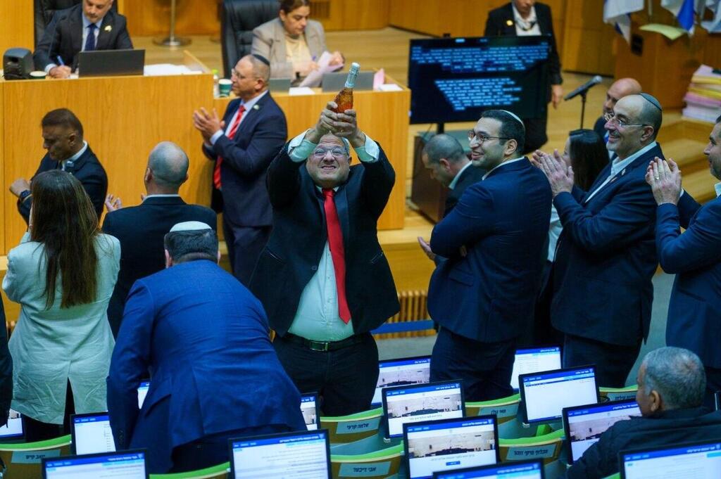 איתמר בן גביר במליאת הכנסת לאחר ההכרזה על אישור חוק עונש מוות למחבלים עם שמפניה בידו