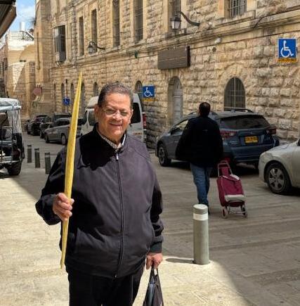 Farah carries his palm branch for Palm Sunday in the deserted streets of the Old City of Jerusalem on April 5