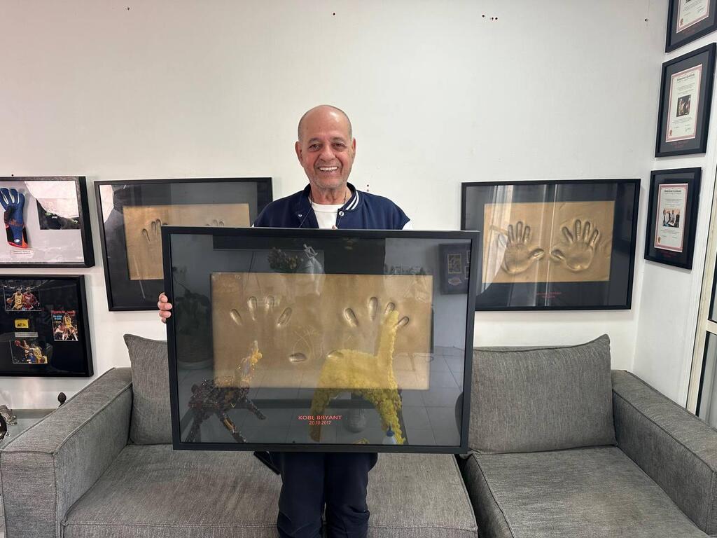 Collector Erez Kaminski holds a framed set of Kobe Bryant handprints from a limited edition series 