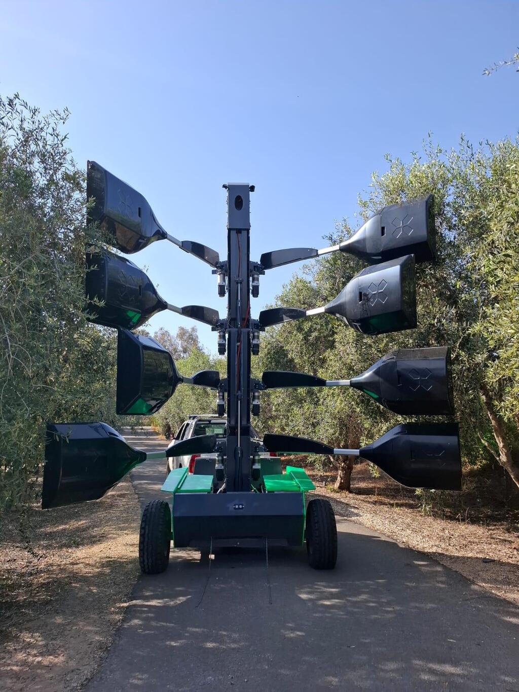 A BloomX robotic pollination system operates between rows of flowering trees at an orchard in Israel in an undated photo, as farmers work to protect yields during a narrow pollination window 