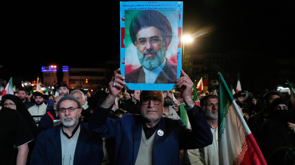 תומכי המשטר האיראני עם תמונתו של מוג'תבא חמינאי