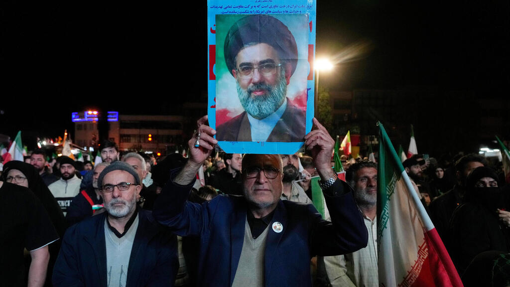 Supporters of the Iranian regime wave a portrait of Mojtaba Khamenei following the ceasefire announcement (Photo: Vahid Salemi/AP) תומכי המשטר האיראני מניפים את תמונתו של מוג'תבא חמינאי לאחר ההודעה על הפסקת האש