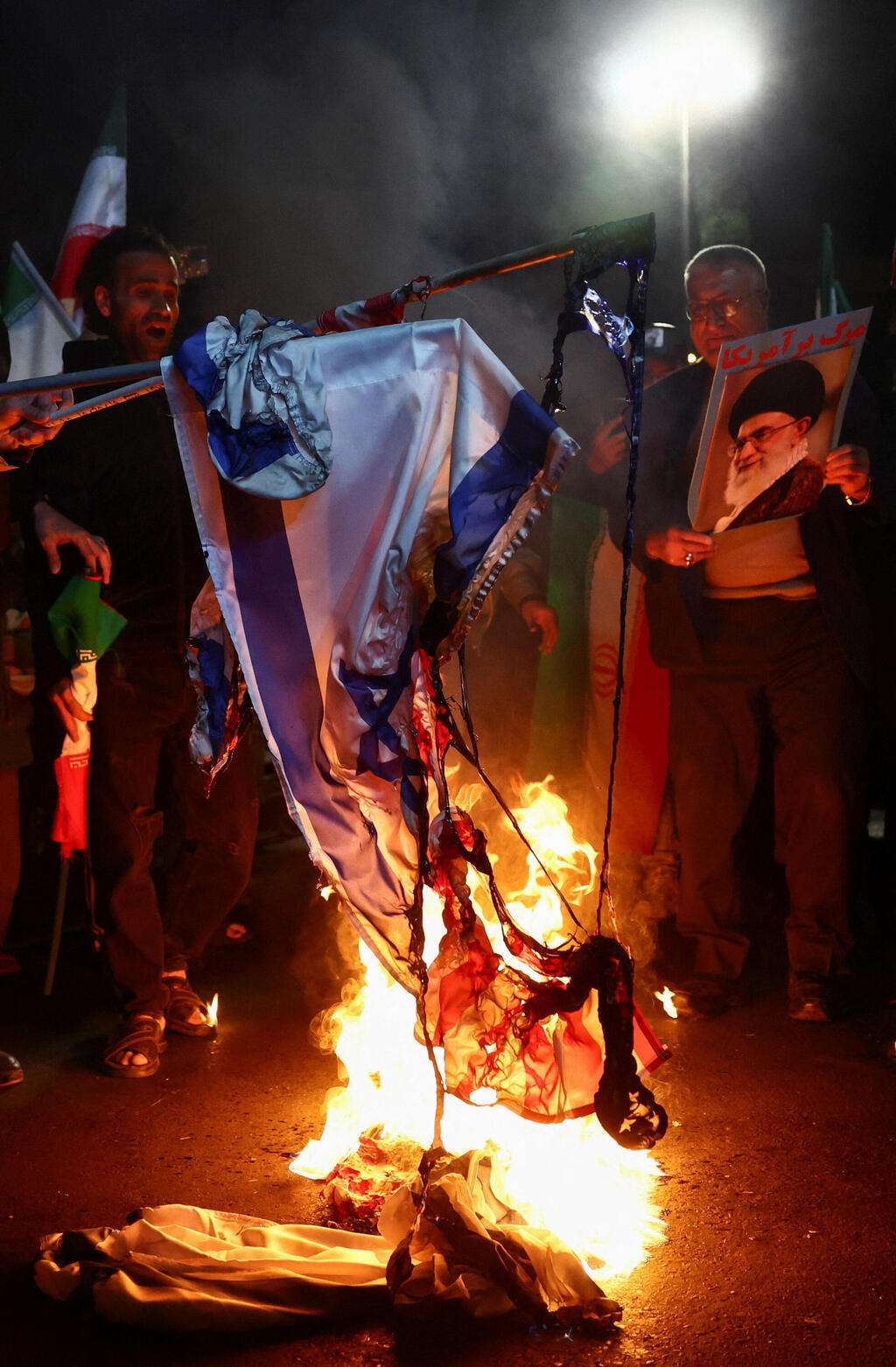 תומכי המשטר האיראני שורפים את דגל ישראל וארצות הברית לאחר ההודעה על הפסקת האש