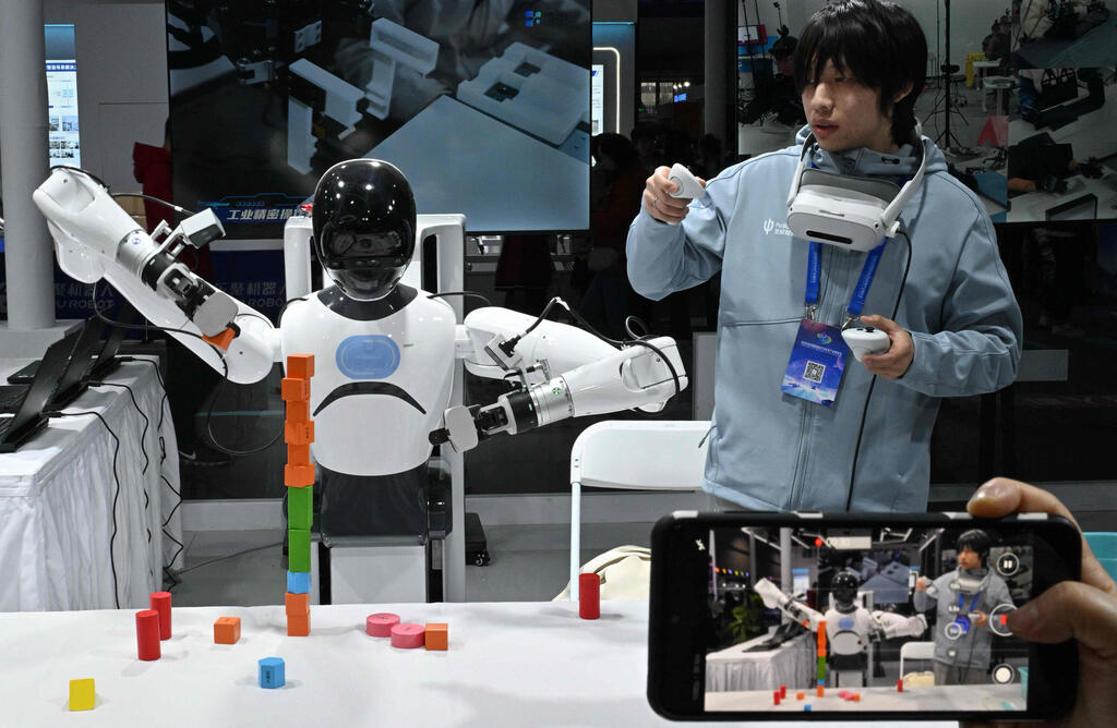 Photo: AFP/Adek Berry רובוט מדגים יכולות עבודה בסיסיות בחברה סינית