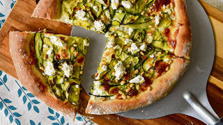 White pizza with zucchini ribbons, cheese and pine nuts