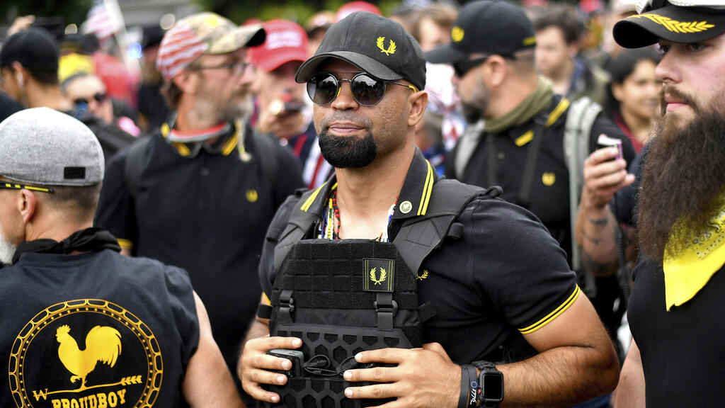 The far-right organization the Proud Boys adopted the black Fred Perry polo shirt with a yellow logo (Photo: AP Photo/Noah Berger) הנרי "אנריקה" טריו, אז מנהיג ארגון The Proud boys, בהפגנה בארצות הברית, 2019