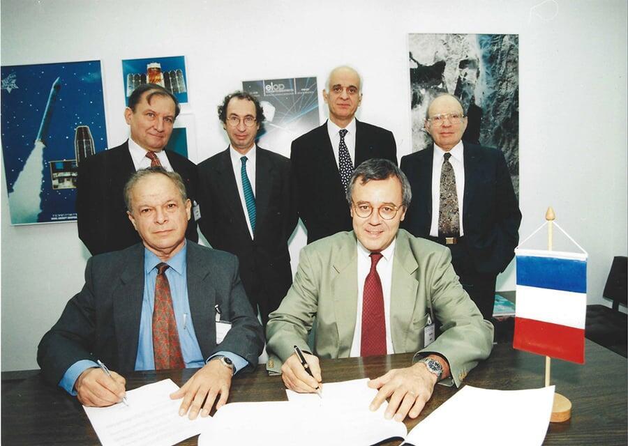 קסם אישי שהוביל לשיתופי פעולה בינלאומיים רבים. הר-אבן (יושב משמאל) חותם עם ראש סוכנות החלל של צרפת, אלן בנסוסן (Bensoussan) על ההסכם שהוביל לשיגור הלוויין המשותף ונוס