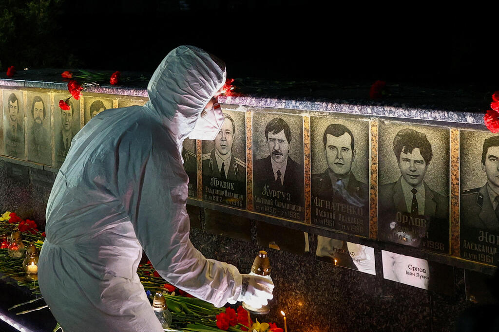 אוקראינה 40 שנה ל צ'רנוביל  עובד המתקן הגרעיני ב צ'רנוביל מניח נרות לזכר הקורבנות