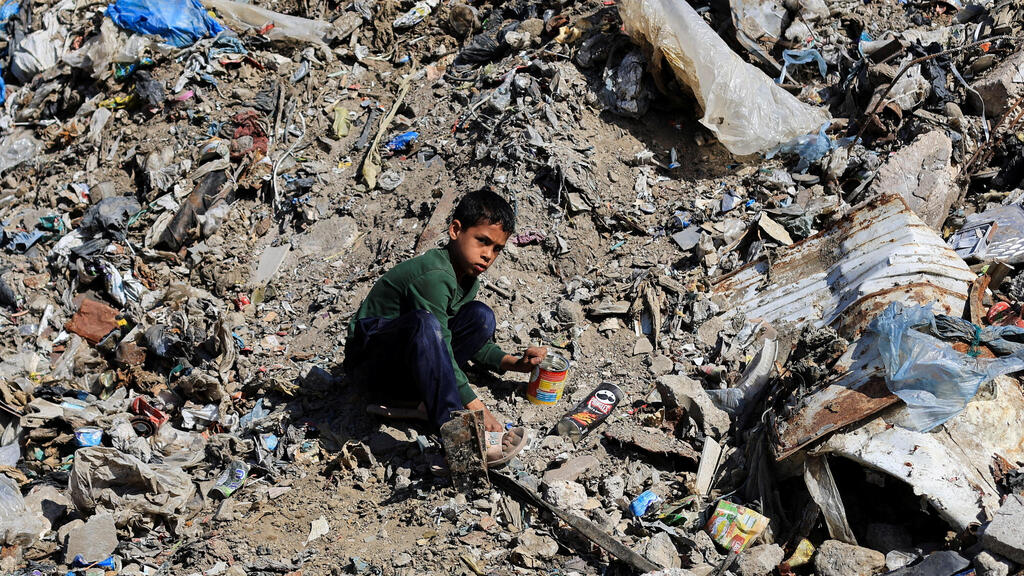 ילד פלסטיני יושב על ערימת הריסות ואשפה ברצועת עזה