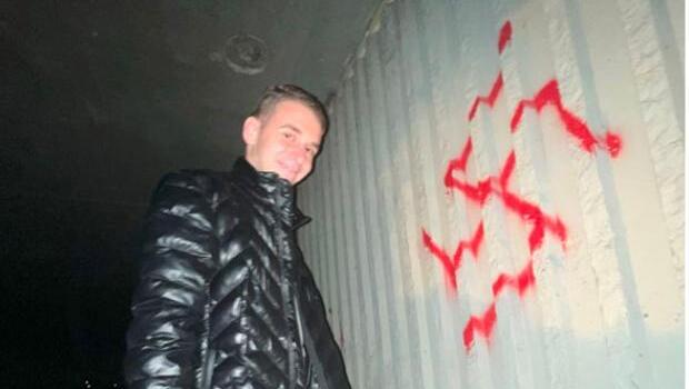 מיכאיל צ'יקווישווילי ליד צלב קרס שריסס