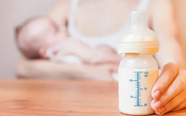 A mother holds a baby, with a bottle of breast milk at foreground (Photo: Pilin_Petunyia/iStock by Getty images) Illustrative: A mother holds a baby, with a bottle of breast milk at foreground