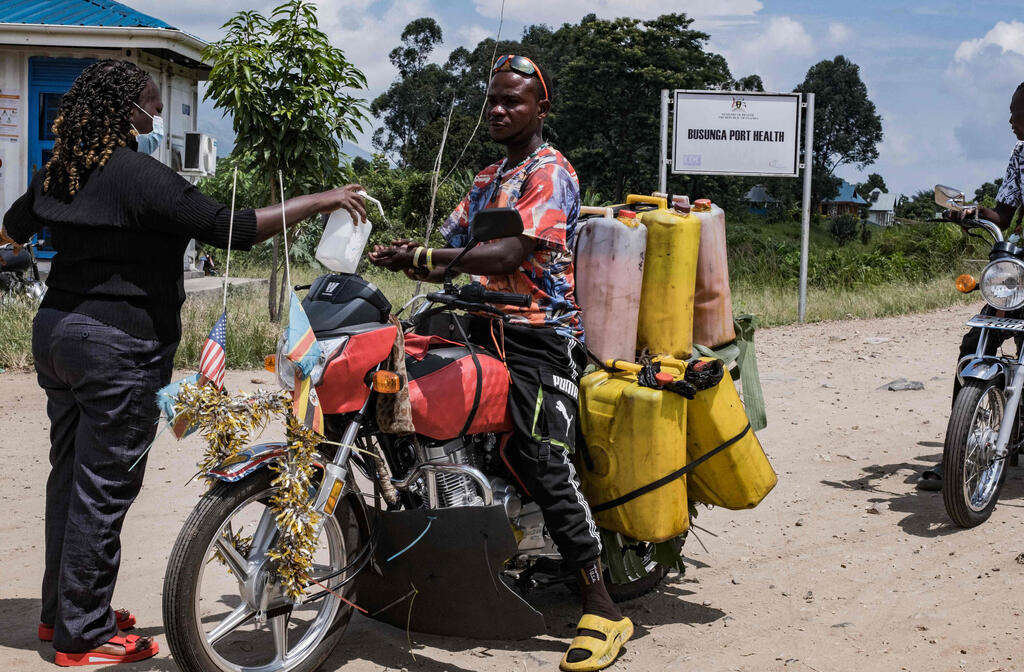 Washing hands with disinfectant at the Uganda-Congo border crossing amid Ebola outbreak (Photo: Badru Katumba / AFP) שוטפים ידיים בחומר חיטוי במעבר הגבול בין אוגנדה לקונגו לנוכח התפרצות אבולה