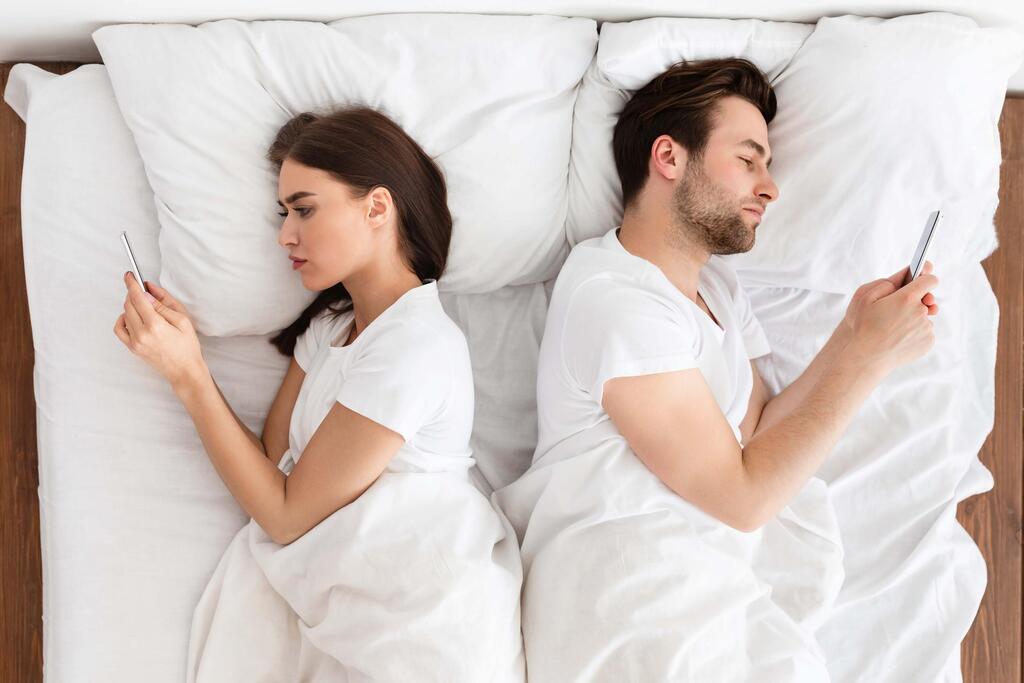 The phone brings work, friends and the entire outside world into the room (Photo: Shutterstock) טלפון בחדר השינה. "לא צריך לזרוק את הטלפון מהחיים, אבל צריך לדעת מתי להניח אותו בצד"