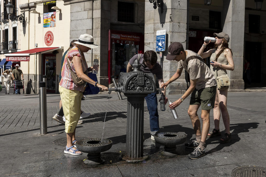 Filling bottles at a drinking fountain in Madrid (Photo: Pablo Blazquez Dominguez/Getty Images) מדריד ספרד גל חום אירופה 23 במאי