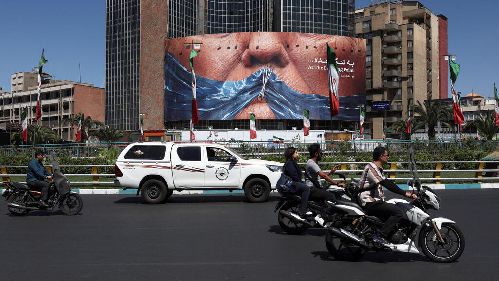 On a road in Tehran, in front of a giant billboard mocking Trump (Photo: Majid Asgaripour/WANA (West Asia News Agency) via REUTERS) טהרן