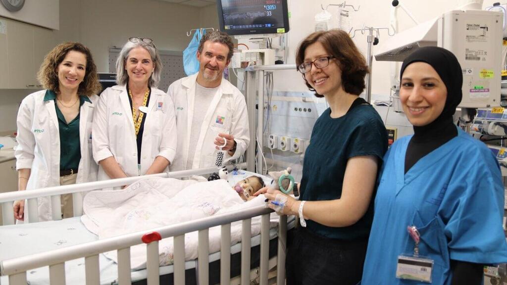 From right: nurse Aya Nasser of Schneider’s intensive care unit; liver lobe donor Dr. Talya Eden; baby Bissan; Dr. Michael Gurevich, director of the Liver Transplant Unit; Dr. Yael Mozer-Glassberg, director of the Liver Transplant Recipients Unit; and Prof. Orit Weisbord-Zinman, director of the Liver Disease Service (Photo: Schneider spokesperson’s office) מימין: האחות איה נאסר ממחלקת טיפול נמרץ בשניידר, תורמת אונת הכבד ד"ר טליה עדן, התינוקת ביסאן, ד"ר מיכאל גורביץ', מנהל יחידת השתלות כבד בשניידר, ד"ר יעל מוזר גלזברג, מנהלת יחידת מושתלי כבד ופרופ' אורית ויסבורד צינמן, מנהלת שירות מחלות כבד בשניידר