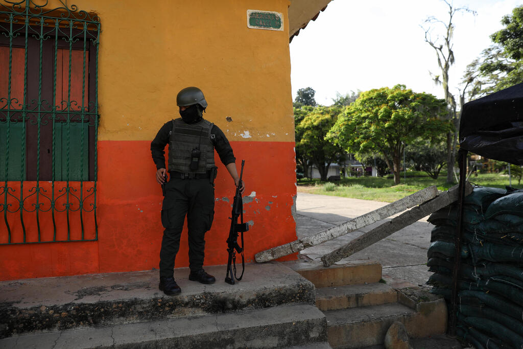 Supporter of leftist Cepeda disguised as "revolutionary" gunman at election rally. Sepada denied connection to FARC underground (Photo: AP Photo/Santiago Saldarriaga) שוטר בתחנת משטרה בעיירה רובלס ב קולומביה שמותקפת על ידי רחפנים
