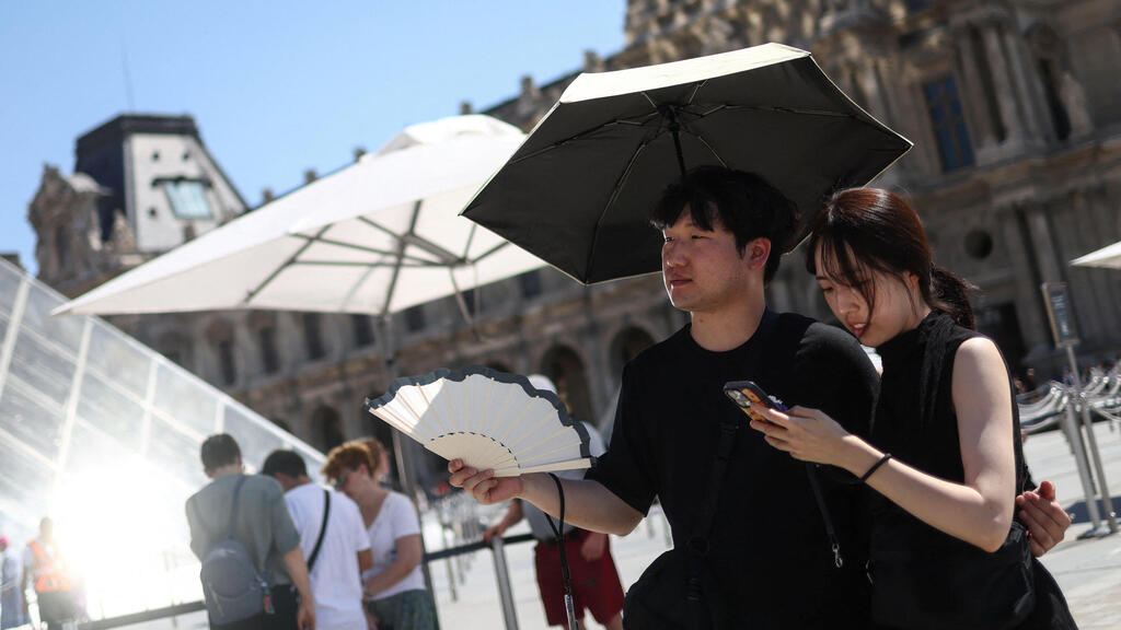 Tourists suffer from the extreme heat wave hitting France (Photo: Tom Nicholson/Reuters) תיירים סובלים מגל החום הקיצוני שפוקד את צרפת