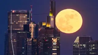 The full moon rises behind the buildings of the banking district in Frankfurt, Germany 