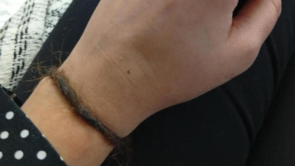 Bracelet made from her hair that had been torn out because she refused to wear a hijab (Photo: The Guardian) צמיד השיער שווידה רבאני הכינה לאחר שמשכו בשיערה בכלא באיראן