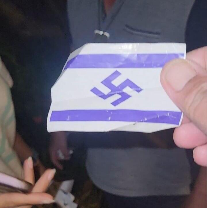 Флажок участника налета דגל ישראל עם צלב קרס חולק למפגינים במחאה על חוק הגיוס מחוץ לביתו של שופט העליון סולברג