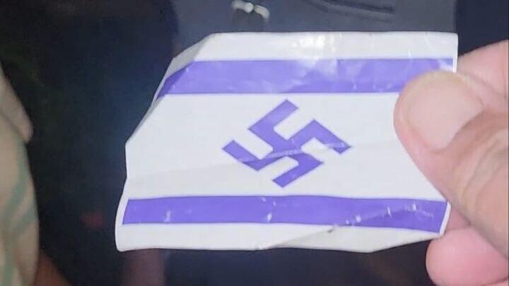 An Israeli flag with a swastika was distributed to protesters דגל ישראל עם צלב קרס חולק למפגינים במחאה על חוק הגיוס מחוץ לביתו של שופט העליון סולברג