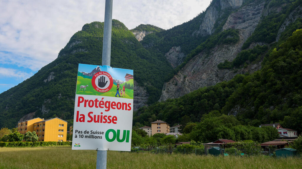 Poster reads: 'Defend Switzerland, not Switzerland with 10 million' (Photo: Denis Balibouse/Reuters) שווייץ משאל עם על הגבלת האוכלוסייה כרזה תגנו על שווייץ לא לשווייץ של 10 מיליון