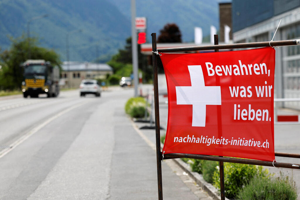 A campaign poster supporting a proposal to limit Switzerland's population growth is displayed along a road ahead of Sunday's referendum (Photo: REUTERS/Stefan Wermuth) שווייץ משאל עם על הגבלת האוכלוסייה כרזה לשמור על מה שיש לנו