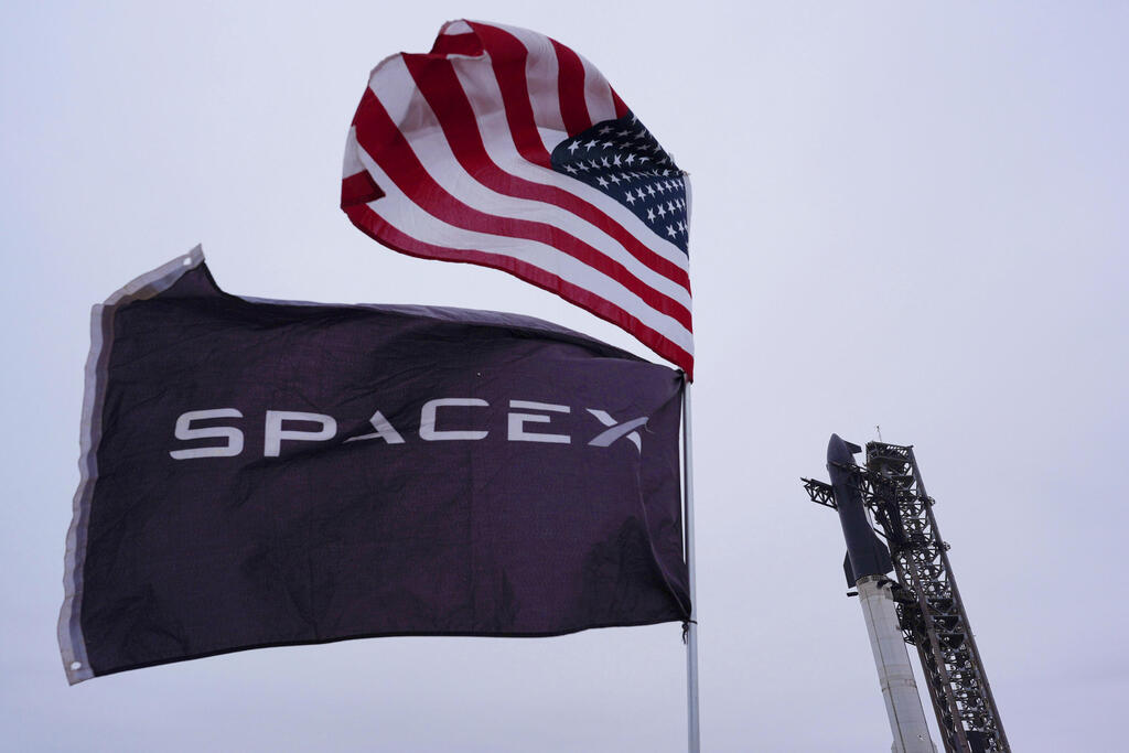 SpaceX set aside 30% of shares for retail buyer (Photo: Eric Gay/AP) דגל ארצות הברית וספייס אקס מתנוססים, ברקע כן השיגור