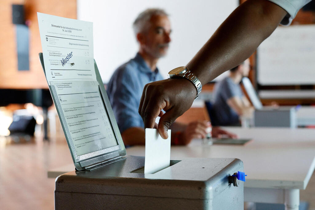 A voter casts a ballot at a polling station in Bern during a nationwide referendum in Switzerland on Sunday (Photo: STEFAN WERMUTH / AFP) A voter casts a ballot at a polling station in Bern during a nationwide referendum in Switzerland on Sunday