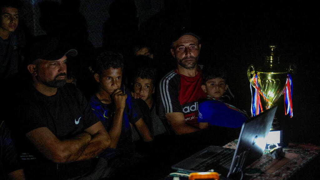Photo: REUTERS/Haseeb Alwazeer עזתים צופים במונדיאל