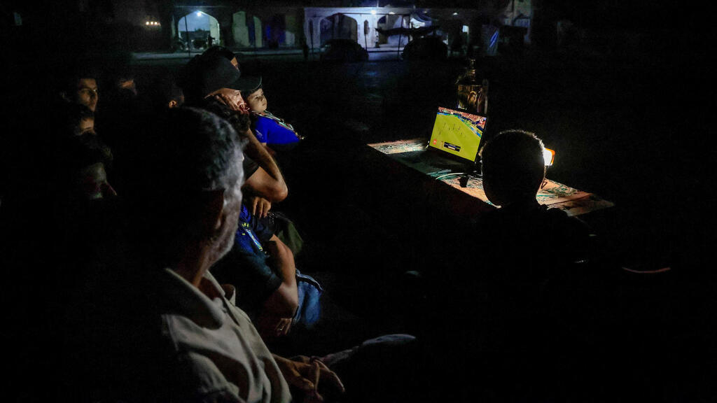 Gazans watching a World Cup match (Photo: REUTERS/Haseeb Alwazeer) עזתים צופים במונדיאל