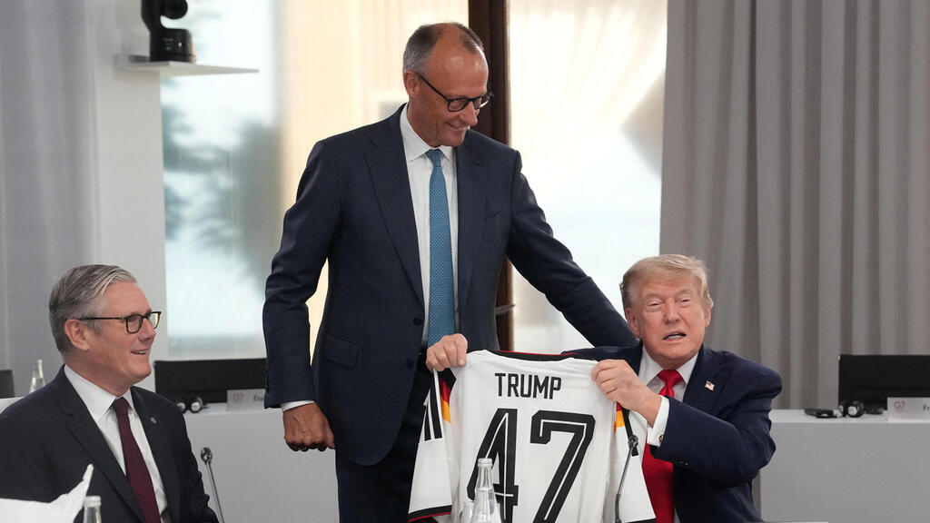 Trump receives a soccer jersey with the number 47 - his number as US president - from German Chancellor Friedrich Merz at the G7 summit (Photo: Camus/Pool via REUTERS) אוויאן צרפת פסגת מנהיגי פורום G7