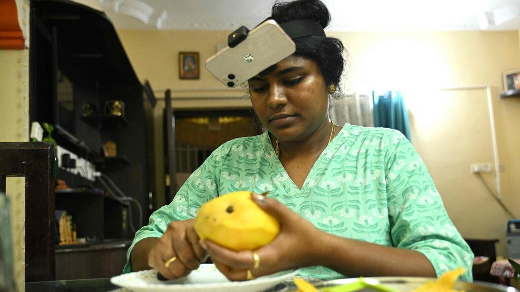 Nagireddy Sriramyachandra films hersef peeling mangoes so AI can learn from her (Photo: R.Satish Babu/AFP) נאגירדי סרירמיאצ'נדרה