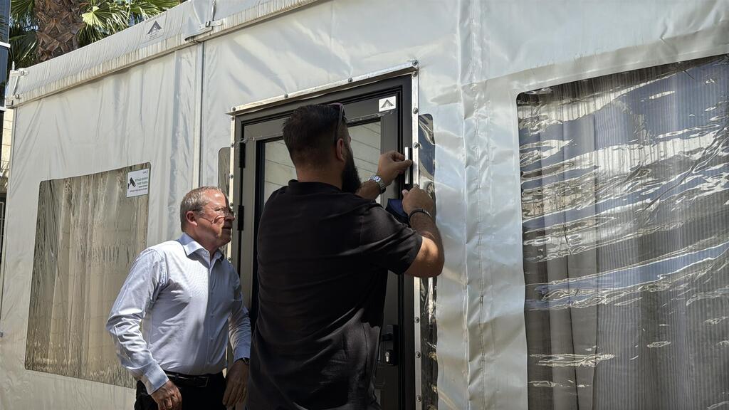 Roi Wasserstein's brother, Tom Wasserstein, hangs mezuzah on the Quiet Tent with Afeka President Yossi Rosenwaks; Roi Wasserstein was an Afeka student soldier whose death by suicide led to conversations with his family, leading to the Quiet Tent Roi Wasserstein's brother, Tom Wasserstein, hangs mezuzah on the Quiet Tent with Afeka President Yossi Rosenwaks. Roi Wasserstein was an Afeka student soldier whose death by suicide led to conversations with his family, leading to the Quiet Tent.