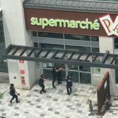 Police officers take positions with weapons drawn during an active shooter response in Montreal's Côte-des-Neiges neighborhood קנדה מונטריאול אירוע ירי
